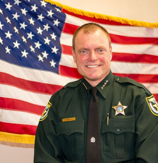 Picture of Sheriff Peyton C. Grinnell with American flag in background